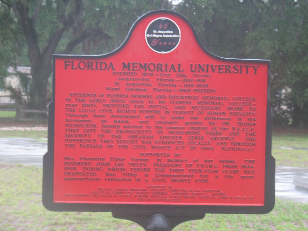 A color photograph of a red historic marker.